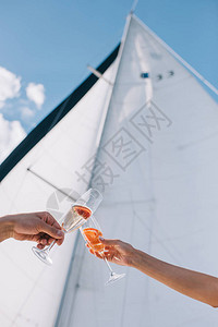 以玻璃杯与游艇上香槟相勾搭的男女图片