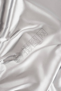 浅银色皱巴闪亮的丝绸面料背景图片
