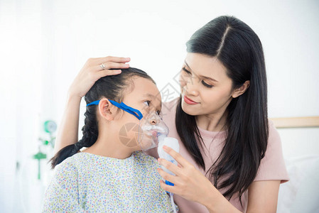 亚裔母亲在医院使用氧气面具时图片