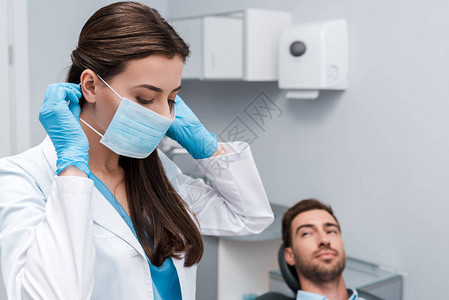 牙科医生在乳胶手套上有选择地重点使用与病人附近的医疗面图片