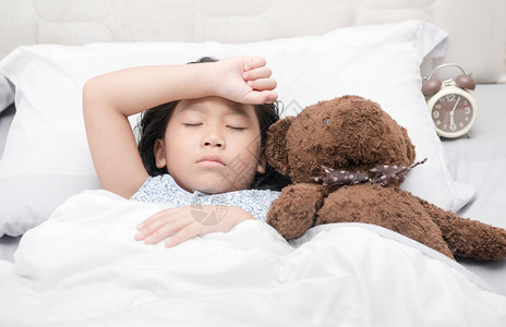 女孩睡觉和生病在床上用泰迪熊娃图片