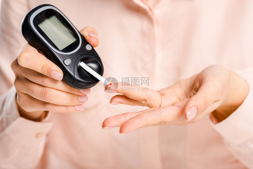 用糖尿病概念分离的血糖仪测量血液中葡萄糖水平的图片
