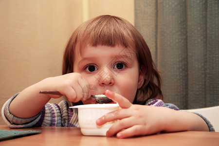 小女孩在家里吃酸奶图片