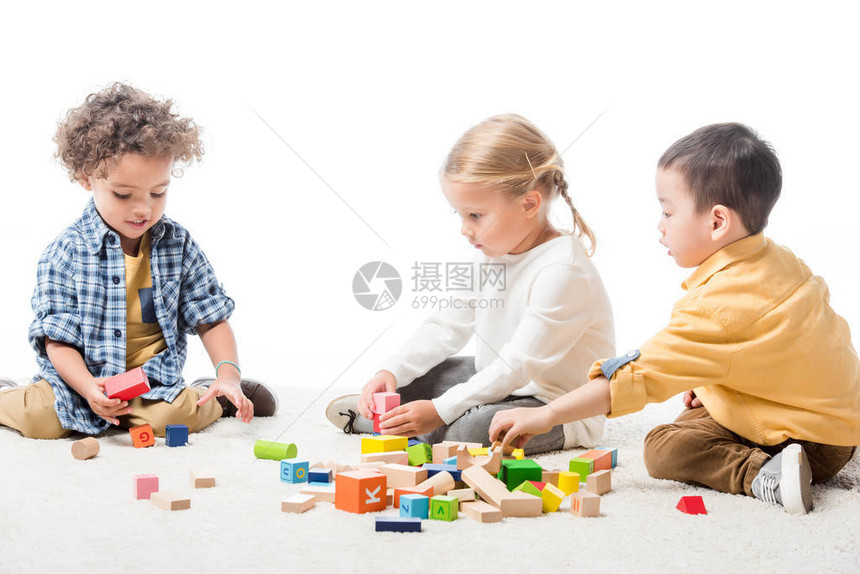 在地毯上玩木砖的多文化儿童孤立在图片