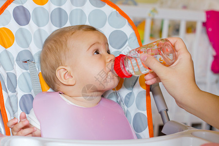 婴儿女孩从瓶子里喝水图片
