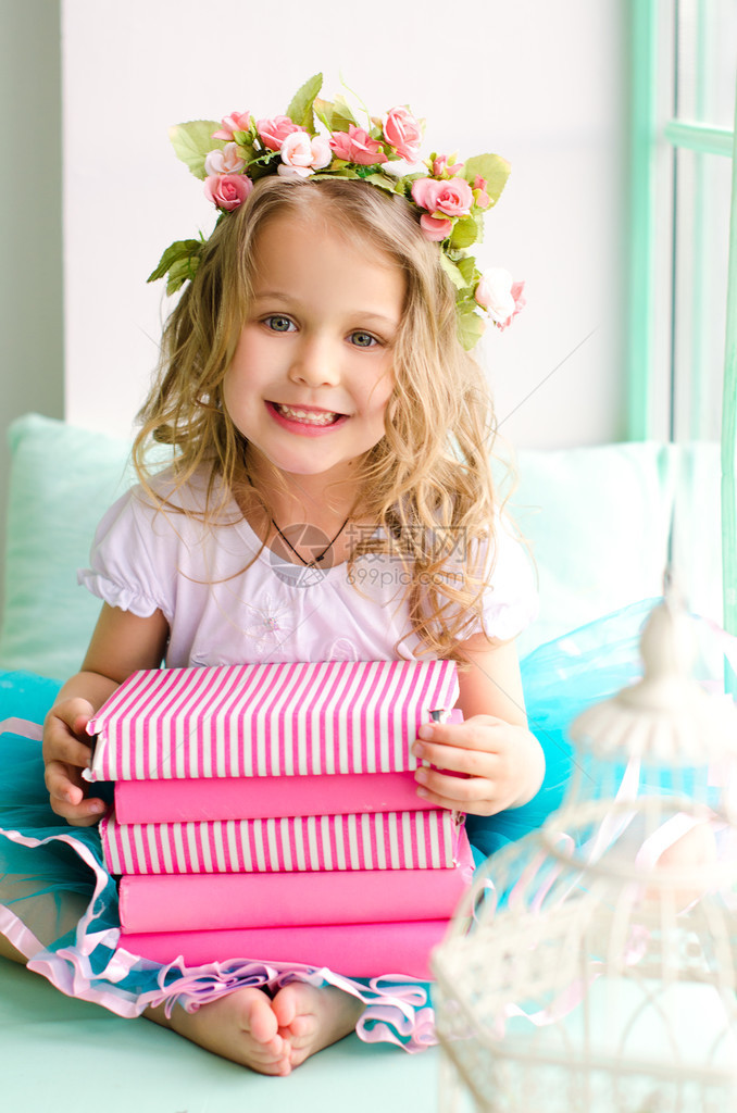 长卷发的可爱小女孩用花圈和一堆粉红图片