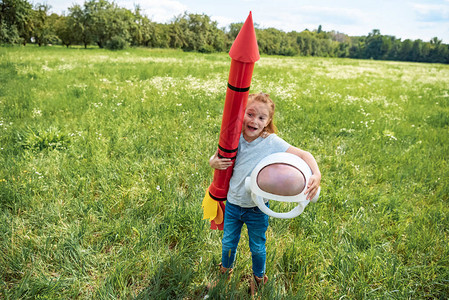身着火箭和宇航员头盔的红发小孩在图片