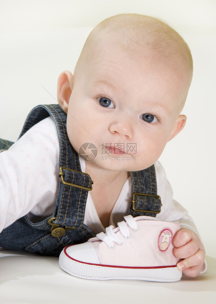 躺着拿鞋的女婴的肖像图片