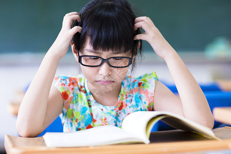 在教室学习的沮丧的小女孩图片