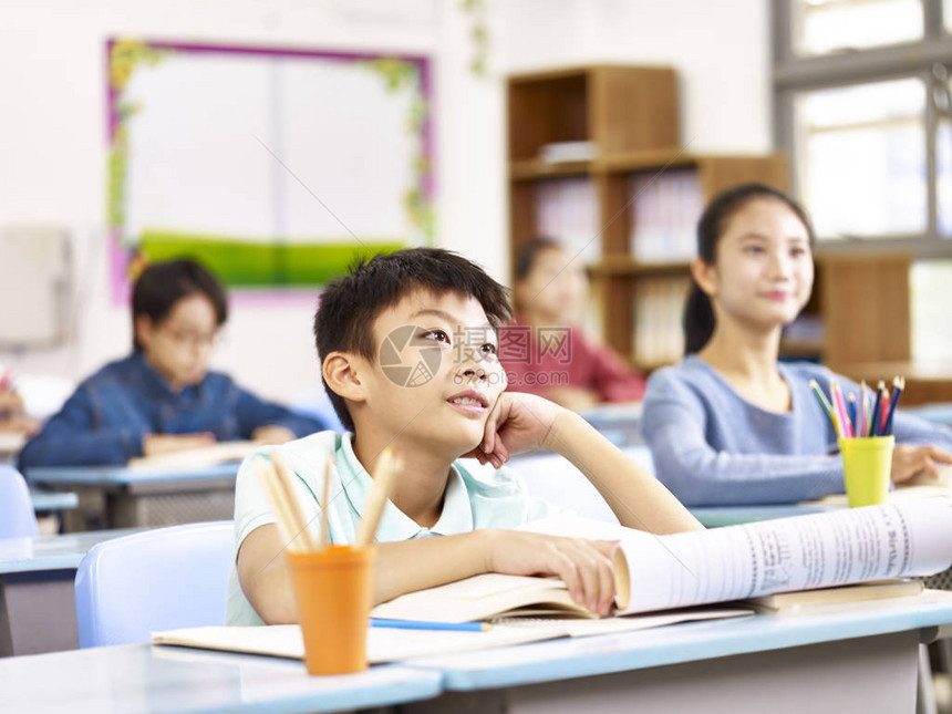 亚洲小学男孩在课堂上认真听老师讲图片