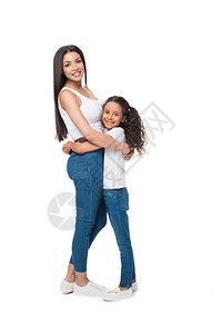 母亲和女儿在看着相机时拥抱对方却被图片