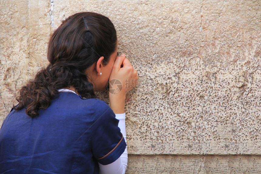 妇女满怀地在西哭墙上祈祷图片