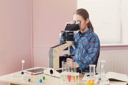 女学生在学校化学或生物学课上用显微镜观察干教育早期开发diy创新图片