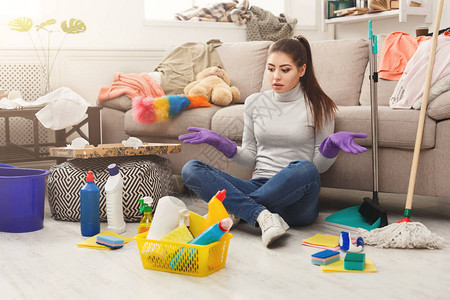 震惊的女人用很多工具打扫房子年轻疲惫的女孩对洗涤剂的数量复印图片