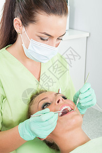 定期对有完美牙齿的女病人进行口腔检查图片