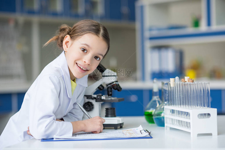 实验室大衣女科学家在剪贴板上写字图片