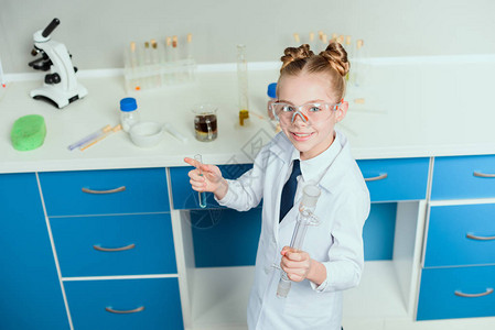戴护目镜的女学生在化学实验室将试剂存放在瓶中背景图片