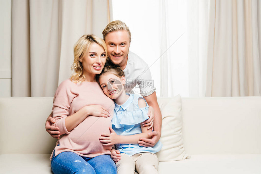 年轻微笑的家庭的肖像坐图片