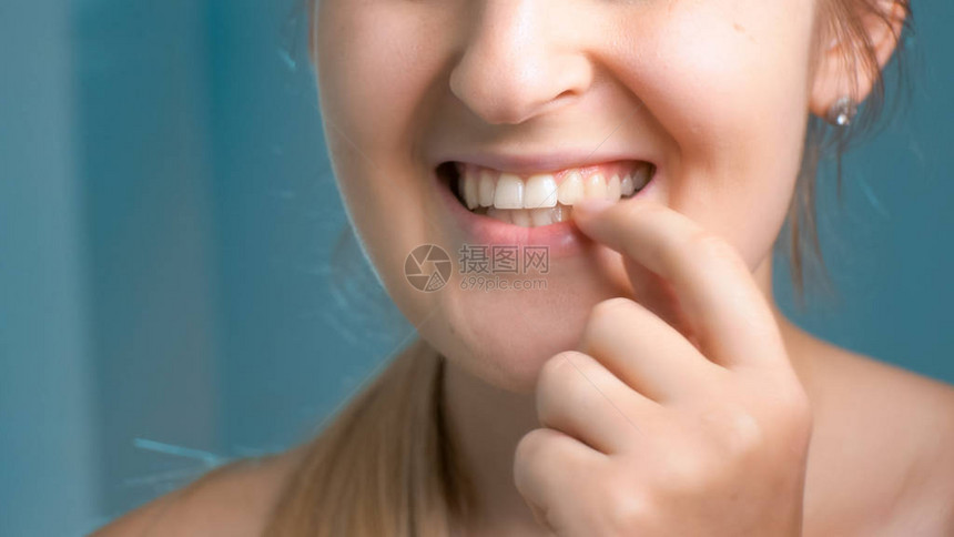 年轻女子在浴室检查牙齿的特写照片图片
