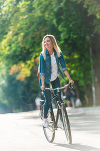 街上带着背包骑自行车的微笑图片
