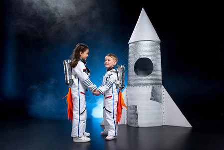 穿着宇航员服装的男女小男孩与女孩手牵图片