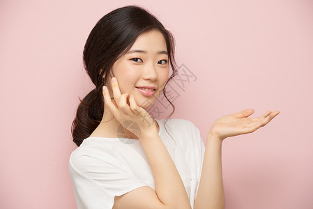 微笑的韩国女孩在脸上涂抹润肤霜图片
