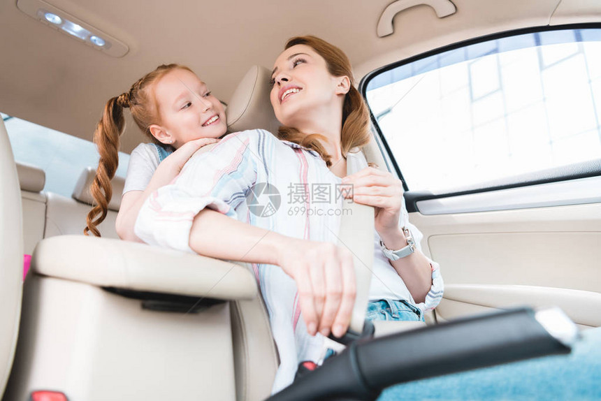 与女儿一起驾驶汽车时妇女系紧安全带图片