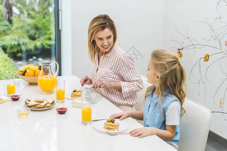 母亲和女儿在家中一起吃早图片