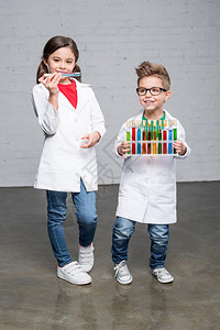 实验室大衣中可爱的小孩用多彩化学样图片
