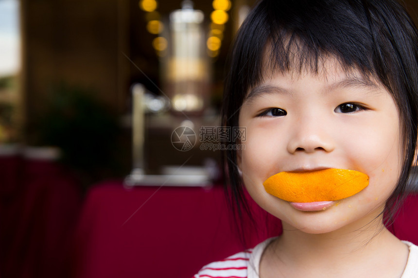 可爱的小女孩吃一片橙色图片