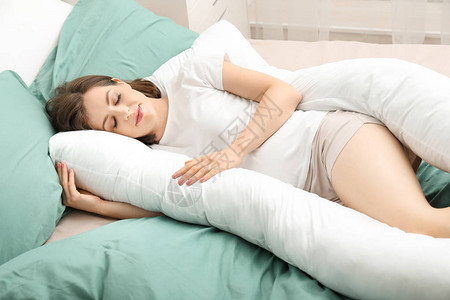 在家睡在产妇枕头上的年轻孕妇图片