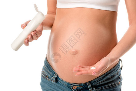 孕妇在肚子上涂化妆乳液以避免白色隔离的伸缩痕迹时图片