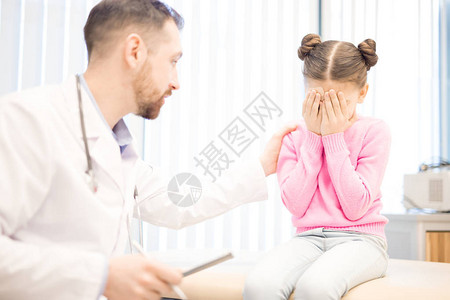 在医院接受医疗期间哭泣的小女孩在医院就诊时得到图片