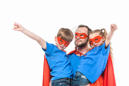 超级父亲带着孩子们戴着面具和斗篷假装是被白色隔图片
