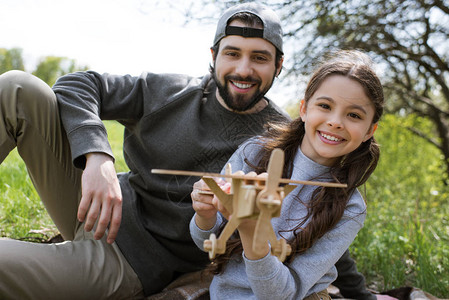 女儿和父亲在公园玩木制玩具飞图片
