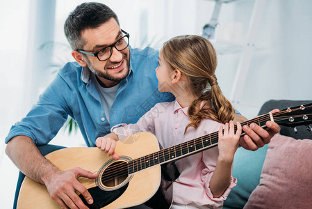父亲在家教女儿弹吉他图片