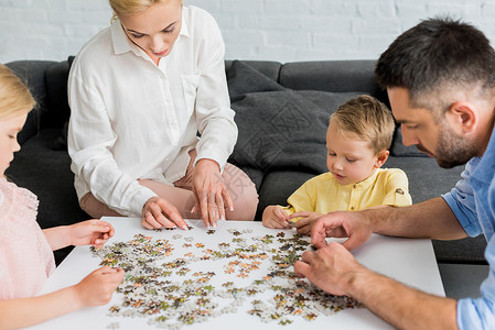 快乐家庭在家里玩拼图游戏的一图片