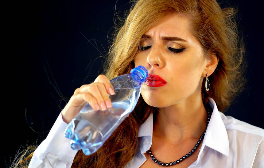 敏感的牙齿女人从瓶子里喝冷水穿着西装喝酒的口渴女孩突然牙痛苦的面部表情闭着眼睛和长发在黑色图片
