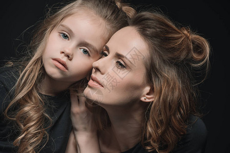 时尚的女儿和母亲的肖像画在黑图片