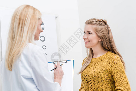 病人和眼科医生后面有诊断和视力表图片