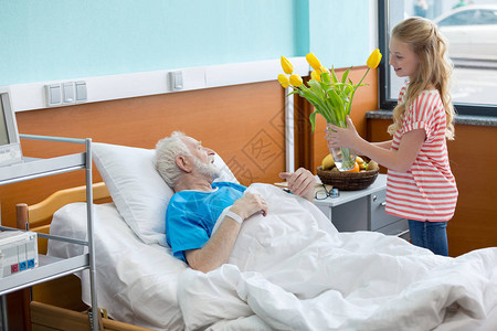 病床上的高级病人和他的孙女拿图片