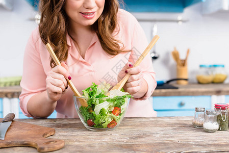 超重女在家中厨房做饭时烹饪新鲜沙图片