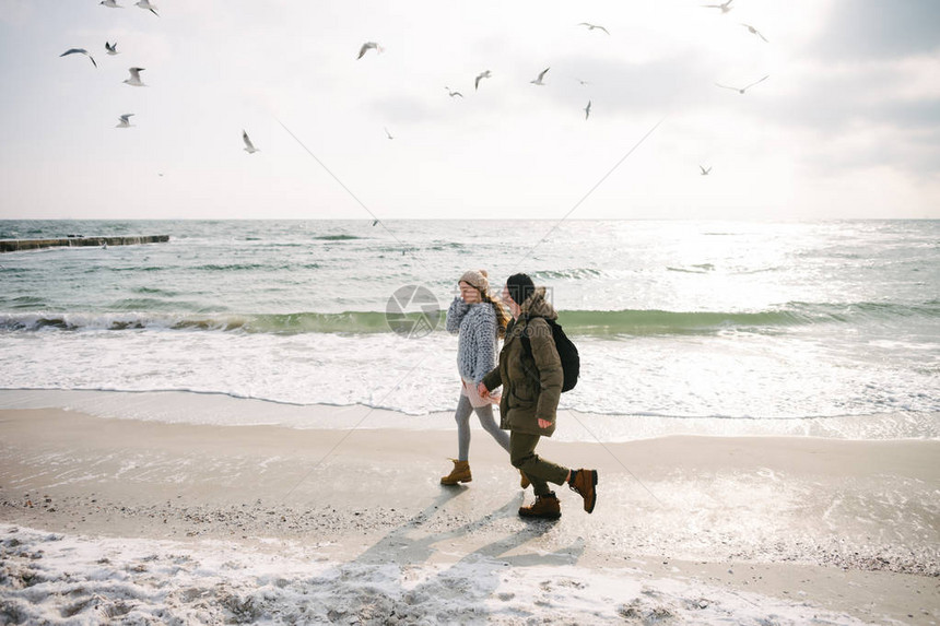 年轻夫妇手牵在冬季海图片