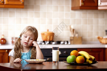 小女孩看着一个盘子厨房里图片