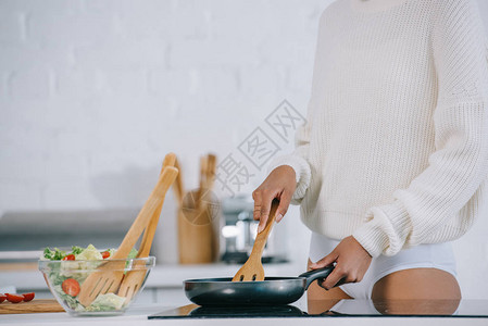 妇女在家用煎锅做早餐时图片