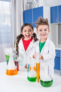 带着快乐的孩子们穿着实验室大衣在化学实验室里装扮图片
