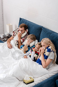 年轻家庭躺在床上时用餐巾纸一起抽鼻涕的疾病图片