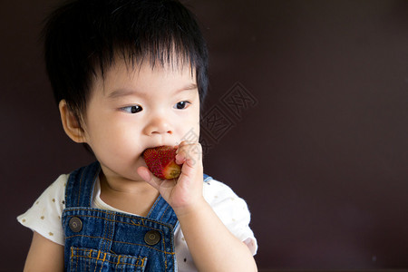 一个小女婴吃草莓的照片图片