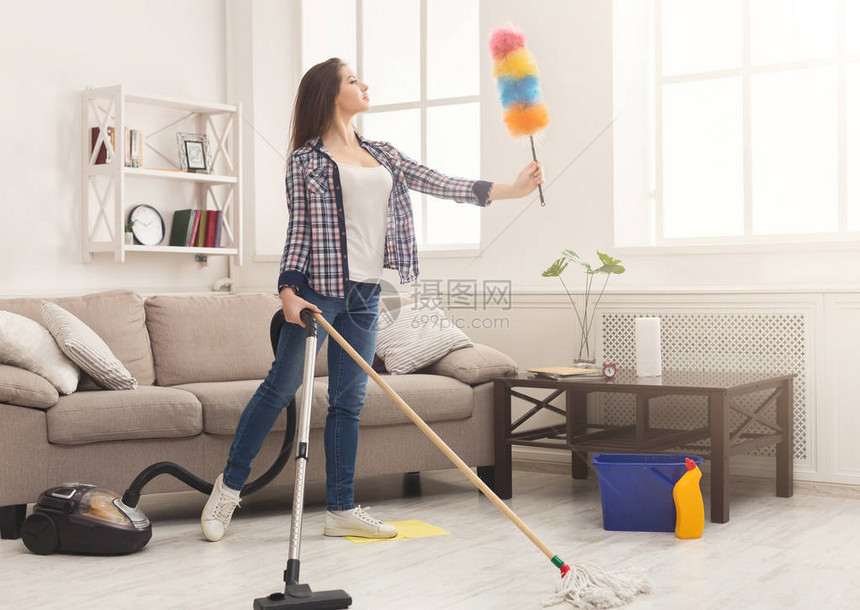 受启发的女人用很多工具打扫房子用拖把和吸尘器洗地板的小女图片