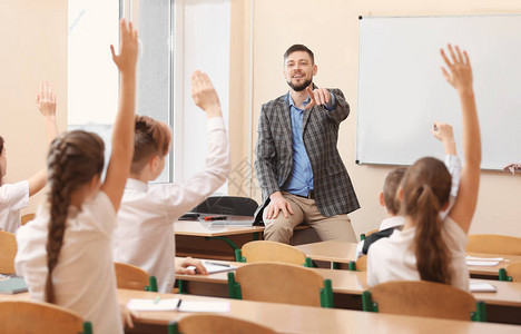学生在课堂上倾听教师和举起手回图片